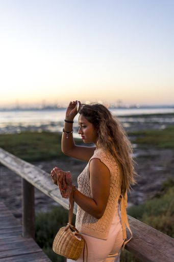 A vertical shot of a young lady with beautiful long hair happily posing for a photo