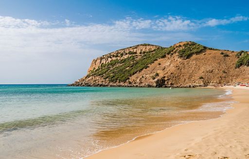 A beautiful shot of a sunny rocky seashore with a cliff on a summer day in Kef Abbed, Tunisia