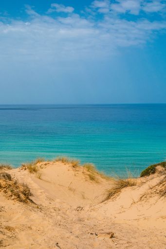 A vertical aerial view of a beautiful seashore with a rocky cliff in Kef Abbed, Tunisia
