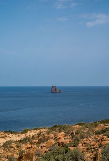 A vertical aerial view of a beautiful seashore with a rocky cliff in Kef Abbed, Tunisia
