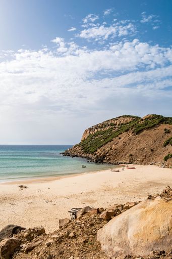A vertical shot of a beautiful seashore with a rocky cliff in Kef Abbed, Tunisia