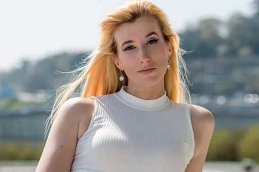 A portrait of an attractive blonde female in a white blouse