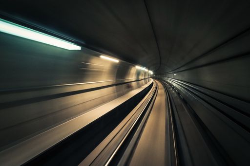 A long exposure shot of an empty tunnel with white lights