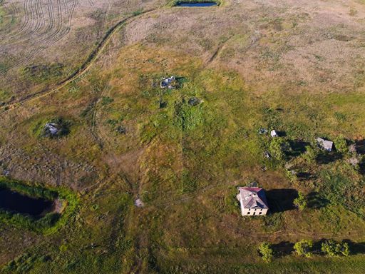 A bird's eye view of an abandoned farmhouse in the prairies of Saskatchewan, Canada