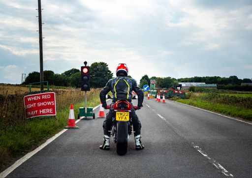 Buxton Derbyshire UK August 2022 man sat on a large modern motorcycle waiting at traffic lights next to road works