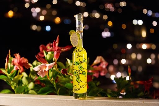A close up shot of a bottle of local liquor Limoncello in Positano with a background of bokeh light effect