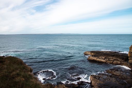 a vertical shot of a rocky hill near the ocean