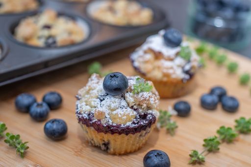 The tasty blueberry muffin in a selective focus on a wooden board