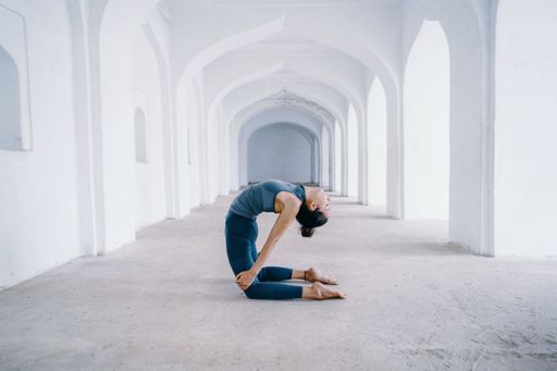 A young female doing asana pose in an ancient Indian temple