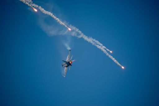 A fighter aircraft flying in the clear blue sky
