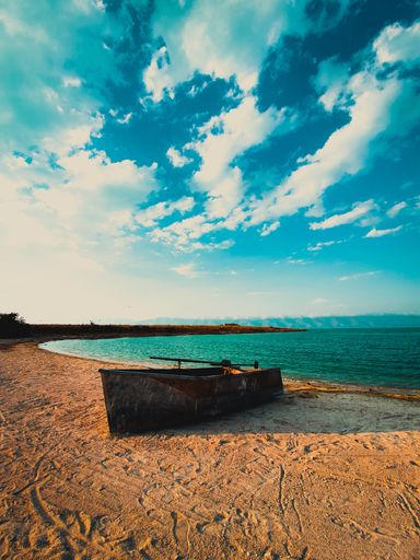 A vertical shot of an old boat on the shore in Sevan Lake, Armenia