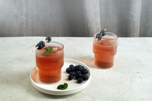 A closeup shot of two glasses of alcoholic cocktails with olives on a table