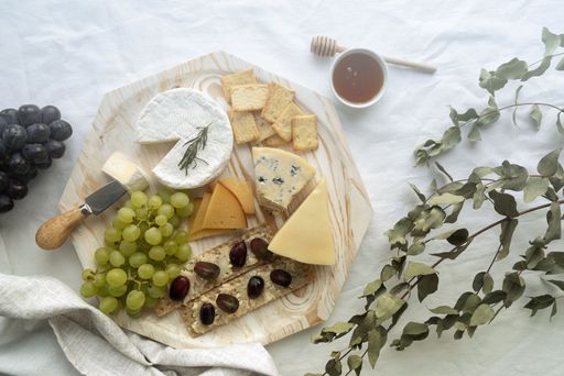 A rustic wooden cheese board filled with a variety of delicious crackers and fruit