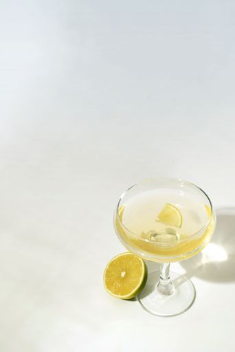 A refreshing drink with freshly cut lemons on a white background