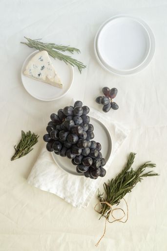 The white porcelain bowls filled with juicy green grapes and creamy white cheese
