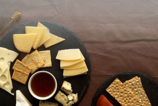A rustic wooden cheese board filled with a variety of delicious crackers and cheese