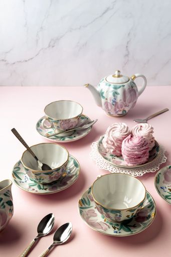 The cups of tea and fresh pastries on a pink table