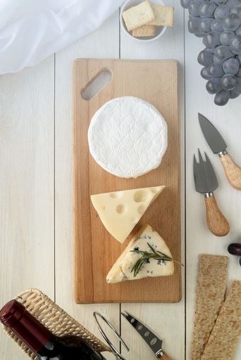A rustic wooden cheese board filled with a variety of delicious crackers and cheese