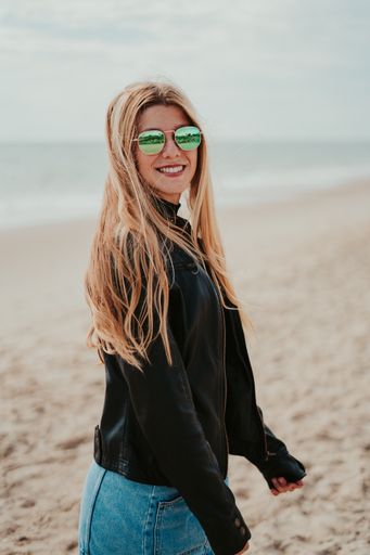 A vertical shot of a beautiful young lady on the beach