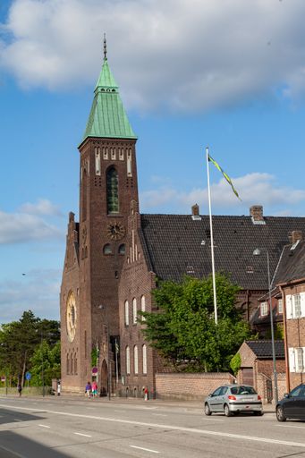 A vertical shot of the Gustaf single clock tower brick church in Copenhagen, Denmark
