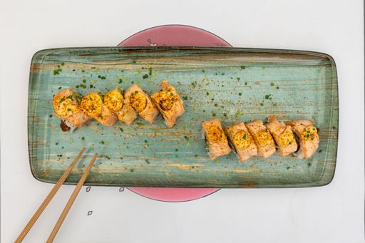 A top view of sushi rolls with chopsticks on the plate