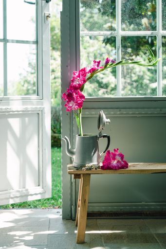 A vertical shot of a vase of beautiful flowers on a wooden chair