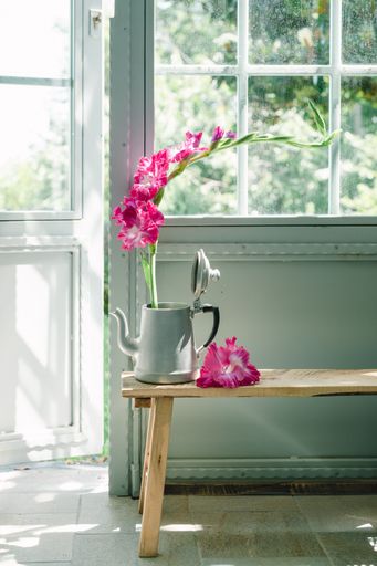 A vertical shot of a vase of beautiful flowers on a wooden chair