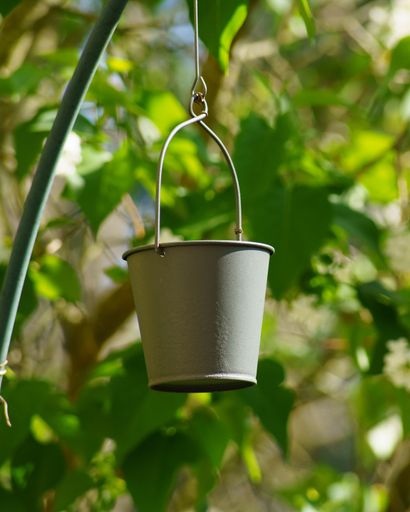 A vertical shot of a bucket hanging on a rope