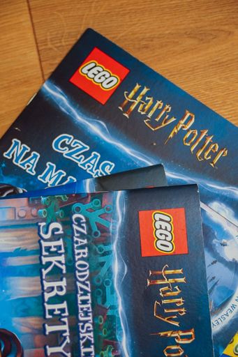 The Lego Harry Potter magazines laying on a wooden floor.
