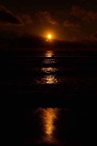A vertical shot of the sunset above the sea. Dark beautiful background.