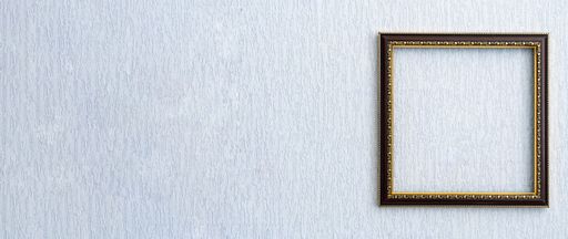 Beautiful frame for picture or photo in black from wooden baguette hangs on light grunge wall.