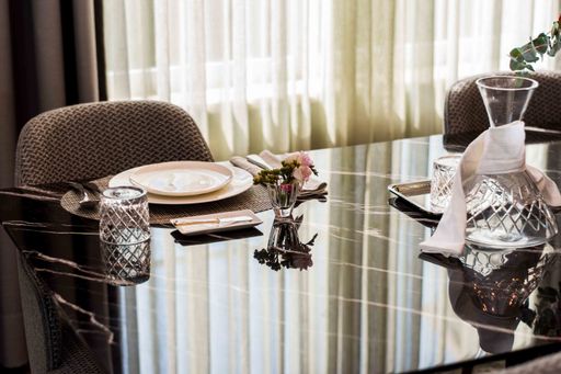 A high angle closeup shot of a luxurious dining table with a small vase of flowers