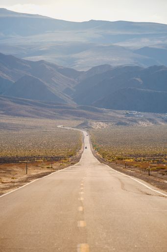 A vertical shot of a road going through the magnificent mountains captured in California