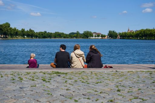 Schwerin, Germany - July 17th 2022: People and friends sitting at the lake and the view and a sunny day