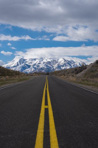 A highway road heading towards a snowy mountain