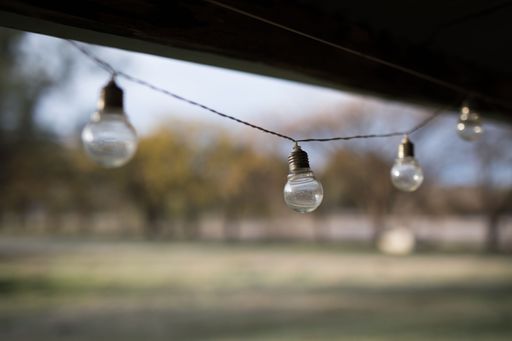 A selective focus on string lights in a yard