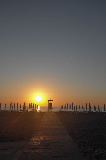 An aerial view of path in background of sea during sunset