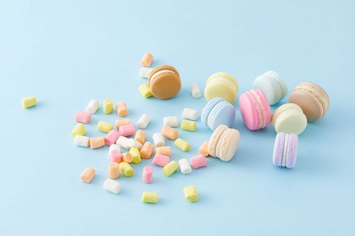 A Closeup of colorful marshmallows and French macaroons isolated on blue background