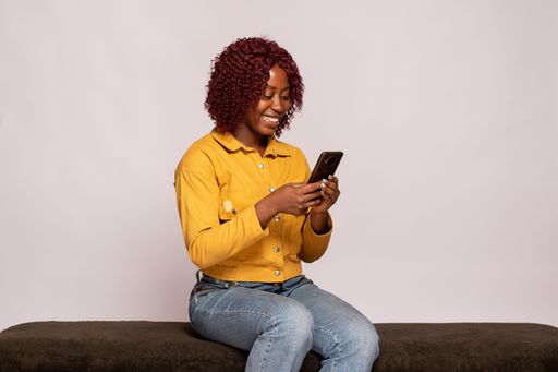 young black lady using her phone smiling