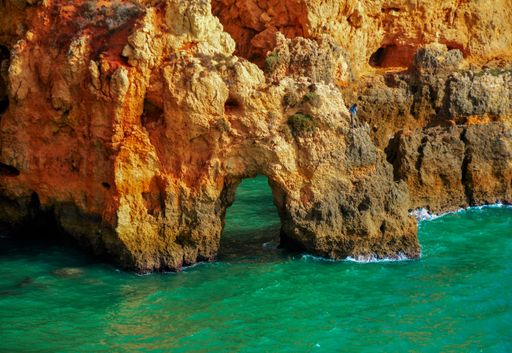A man standing on the Ponta da Piedade rocky cliffs in Lagos, Portugal