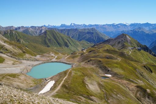 An alpine lake surrounded by green mountains. Silvretta High Alpine Road, Switzerland.