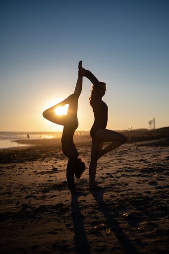 Two women doing yoga on the beach at sunset at Horseneck Beach