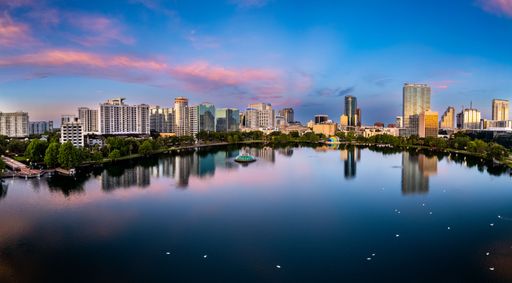 An aerial view of lake Eola and the Orlando city skyline at sunrise