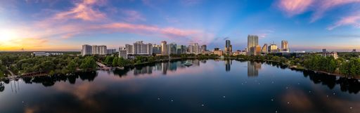 A panoramic shot of lake Eola and the Orlando city skyline at sunrise