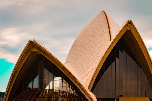 The facade of the famous Sydney Harbour Opera house against a cloudy sky