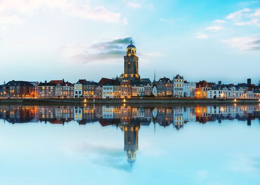 A beautiful view of a city with lights and a reflection in the water in Deventer, Netherlands