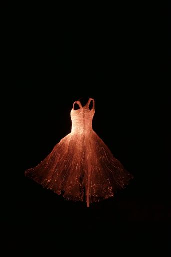 A vertical shot of the ghostly lit dress aginst a black backgroud