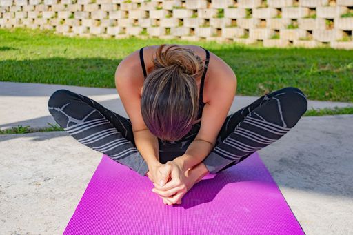 A closeup shot of a young female in black sportswear doing yoga poses and meditating in a park