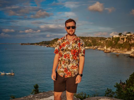 A man in a colorful shirt posing on the background of the sea
