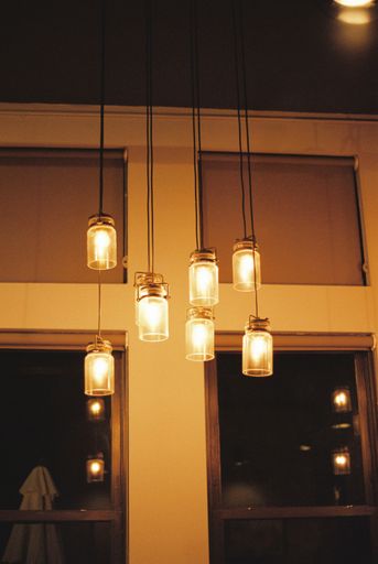 A vertical shot of chandelier with hanging lamps lights on